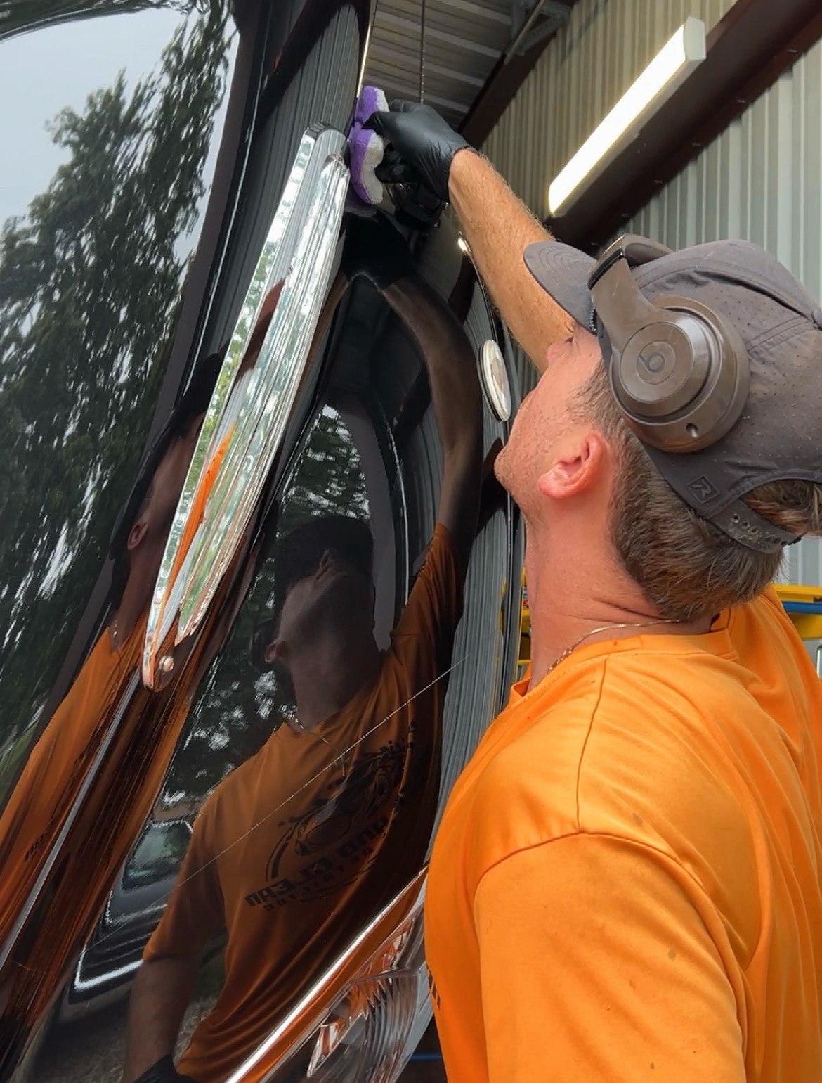 Quick & Clean technician applying exterior care to an RV